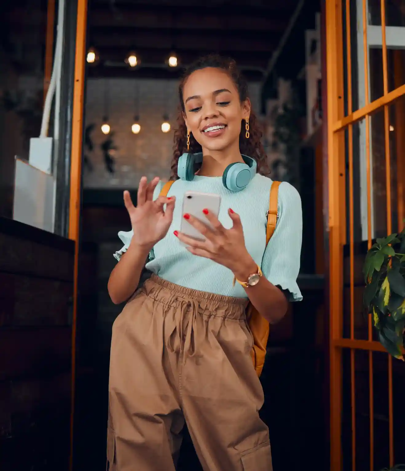 Smiling young woman holding her phone closing the AuDela: Guided Hypnosis app after a successful session